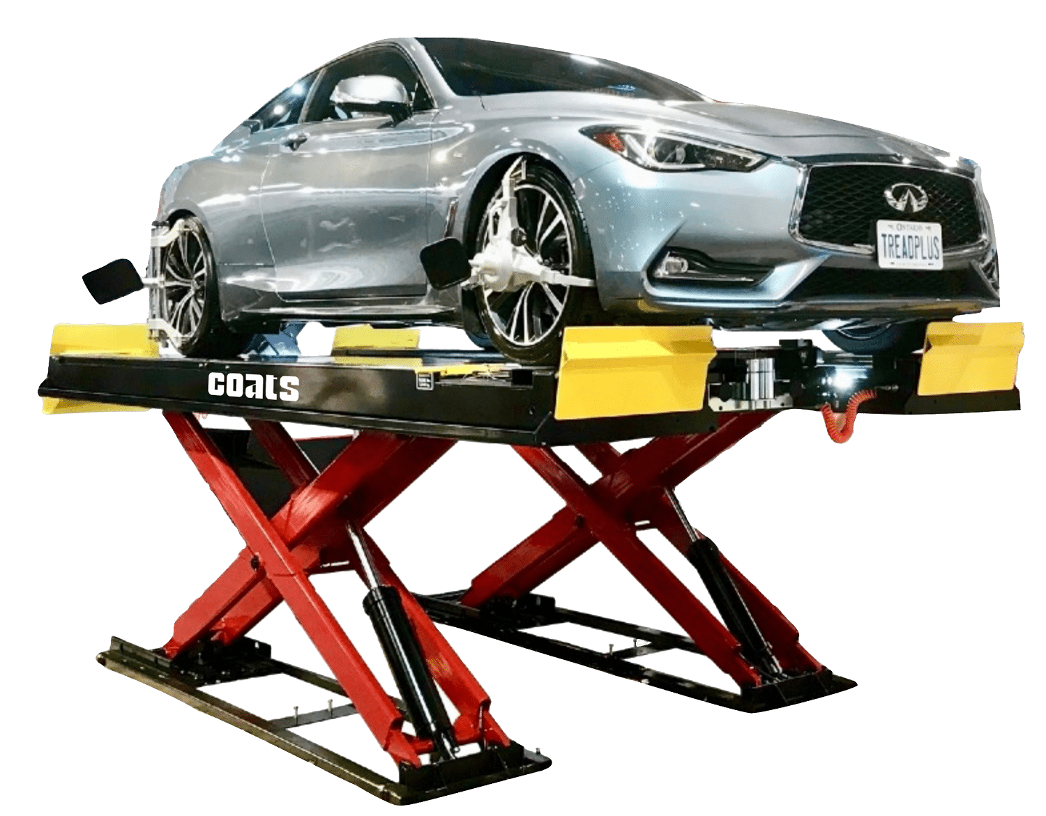 A Coats 12K alignment scissor lift with yellow front plate stops has a silver sedan resting on top of the lift