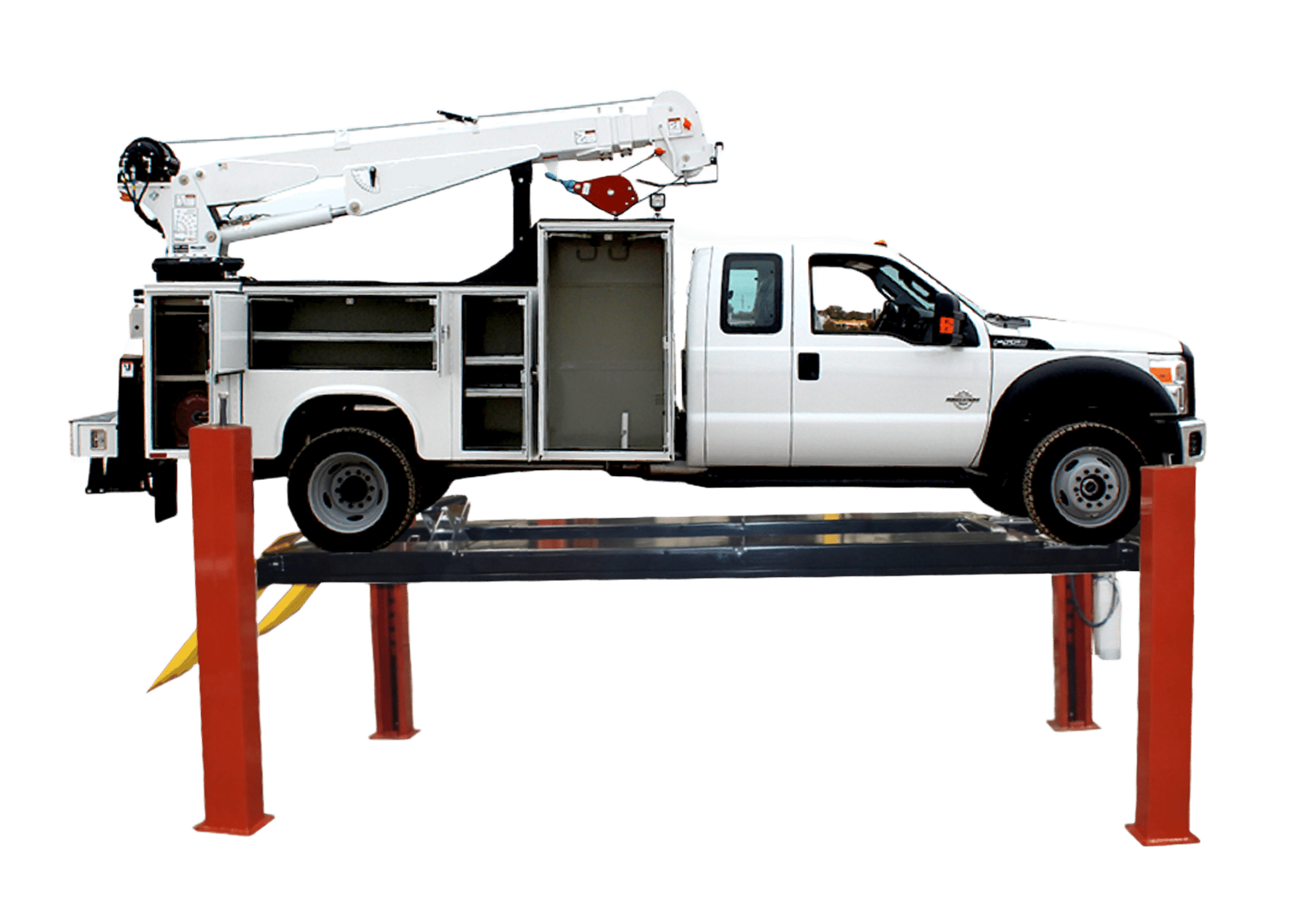 A large, white truck with a construction crane sits on a closed front four post lift