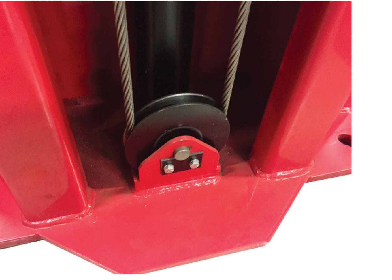 A black pulley on the inside groove of the base of the lift column has a strong, steel cable around it