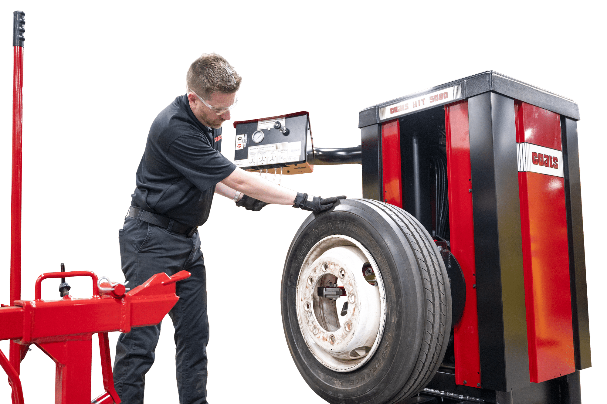 A technician has a hand placed on a tire mounted on a heavy duty tire changer in order to adjust and center the tire on the jaws of the machine