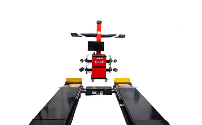 A Coats wheel aligner is centered in front of an alignment lift that is lowered completely to the ground