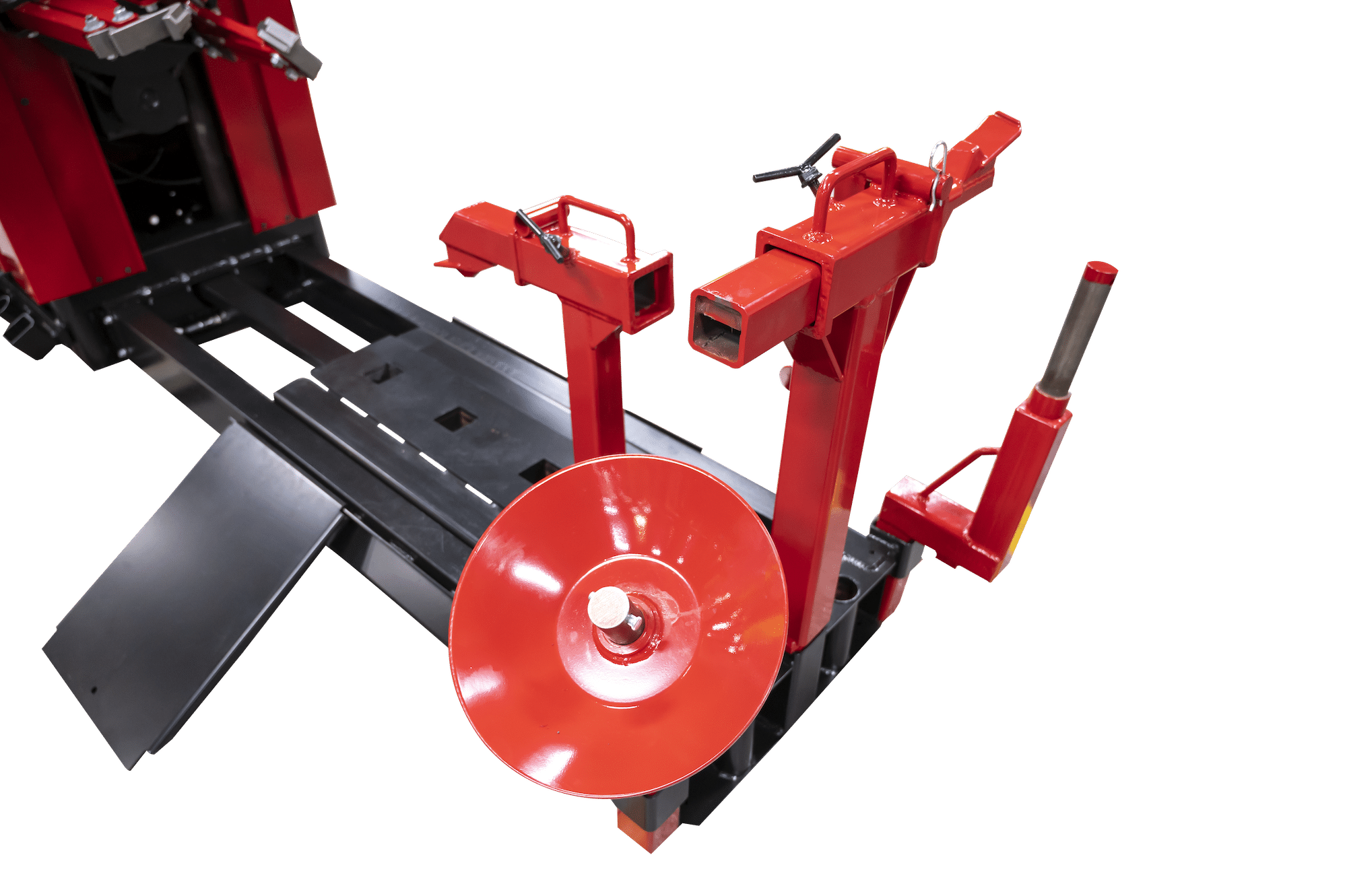 A red disc shaped bead loosener tilted at an angle on a heavy duty tire changer