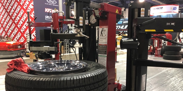 A Coats rim clamp tire changer has a tire on the tabletop and is exhibited on the show floor at the 2019 SEMA Show