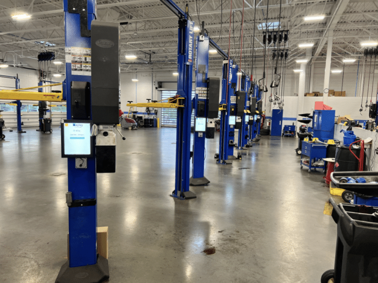 A dealership has service bays lined up and equipped with Bayley touchscreen tablets