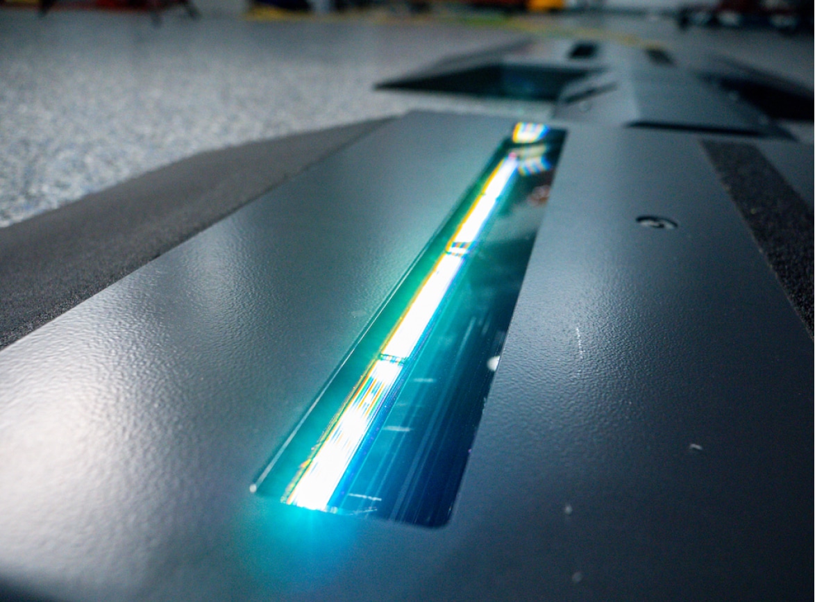 The LED lights of the Coats tread depth scanner are glowing bright turquoise.