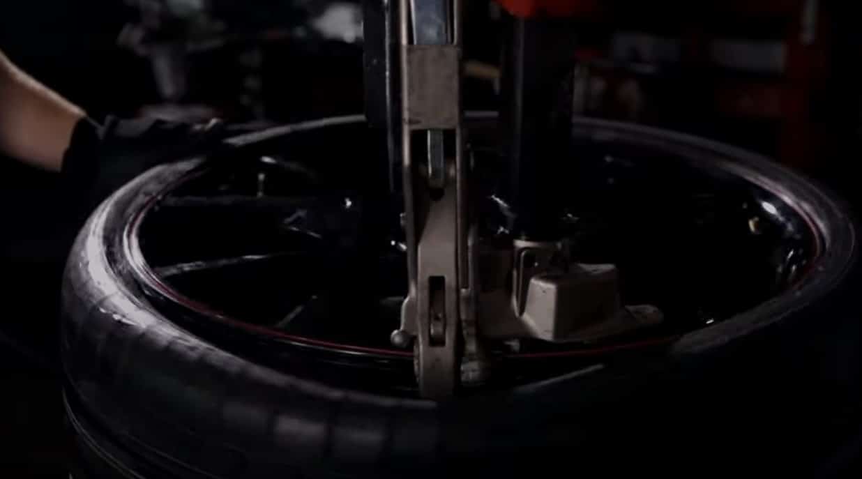 A youtube video is linked showing a technician lowering the metal duckhead tool to hook under a tire can and lift the tire up and away from the wheel while the entire wheel assembly is rotating.