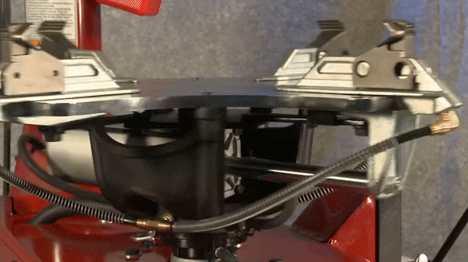 The steel turntable is rotating clockwise as the rim clamps converge toward the center of the turntable