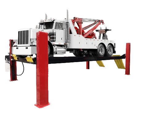 A large white tow truck sits on a Coats, red 4 post lift