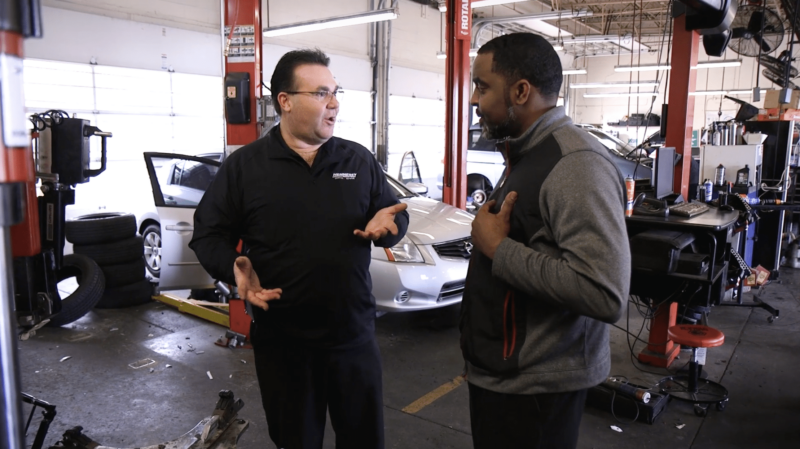 A Coats service tech on the left talks to a customer on the right about Coats equipment