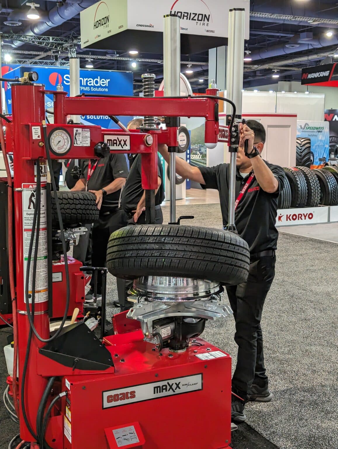 Coats salesman shows a demonstration of how to use the Coats MAXX 80 Tire changer at the trade show.