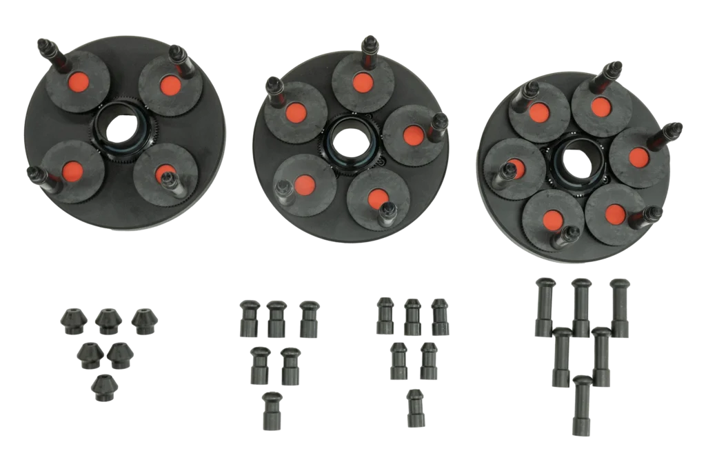 3 black plates with black and red gear plates are laid side by side. Below the 3 plates are 4 sets of 6 tips that are different lengths and shapes