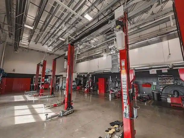 costco tire service bay with red two post lifts and wheel balancers and tire changers